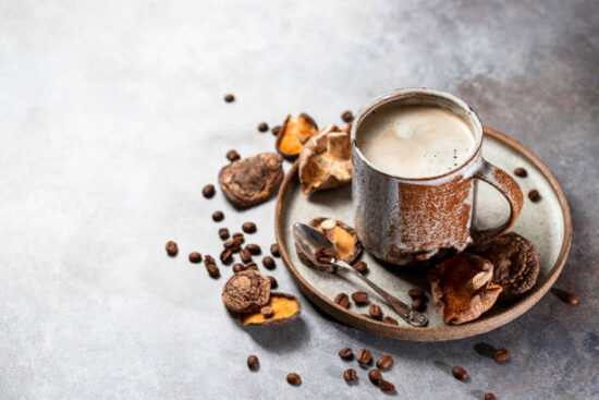 Mushroom coffee, a ceramic cup, mushrooms and coffee beans on stone concrete background. New Superfood Trend. Copy space, selective focus.