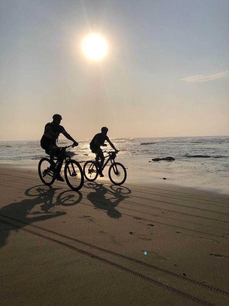 two cyclists on the beach