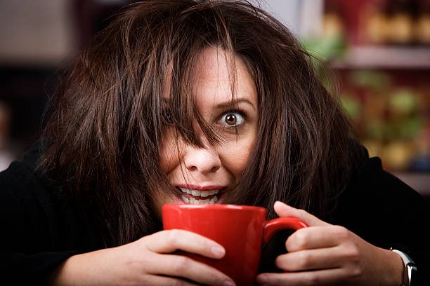 An exhausted woman drinking a cup of coffee