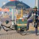 man standing next to a coffee bicycle